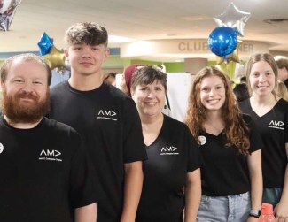 Group of 4 college student volunteers in black AMA shirts